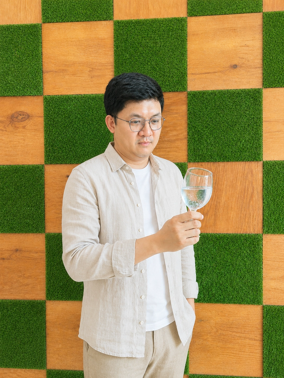 Kenneth Khoo, Certified Water Sommelier, holding a glass of fine water